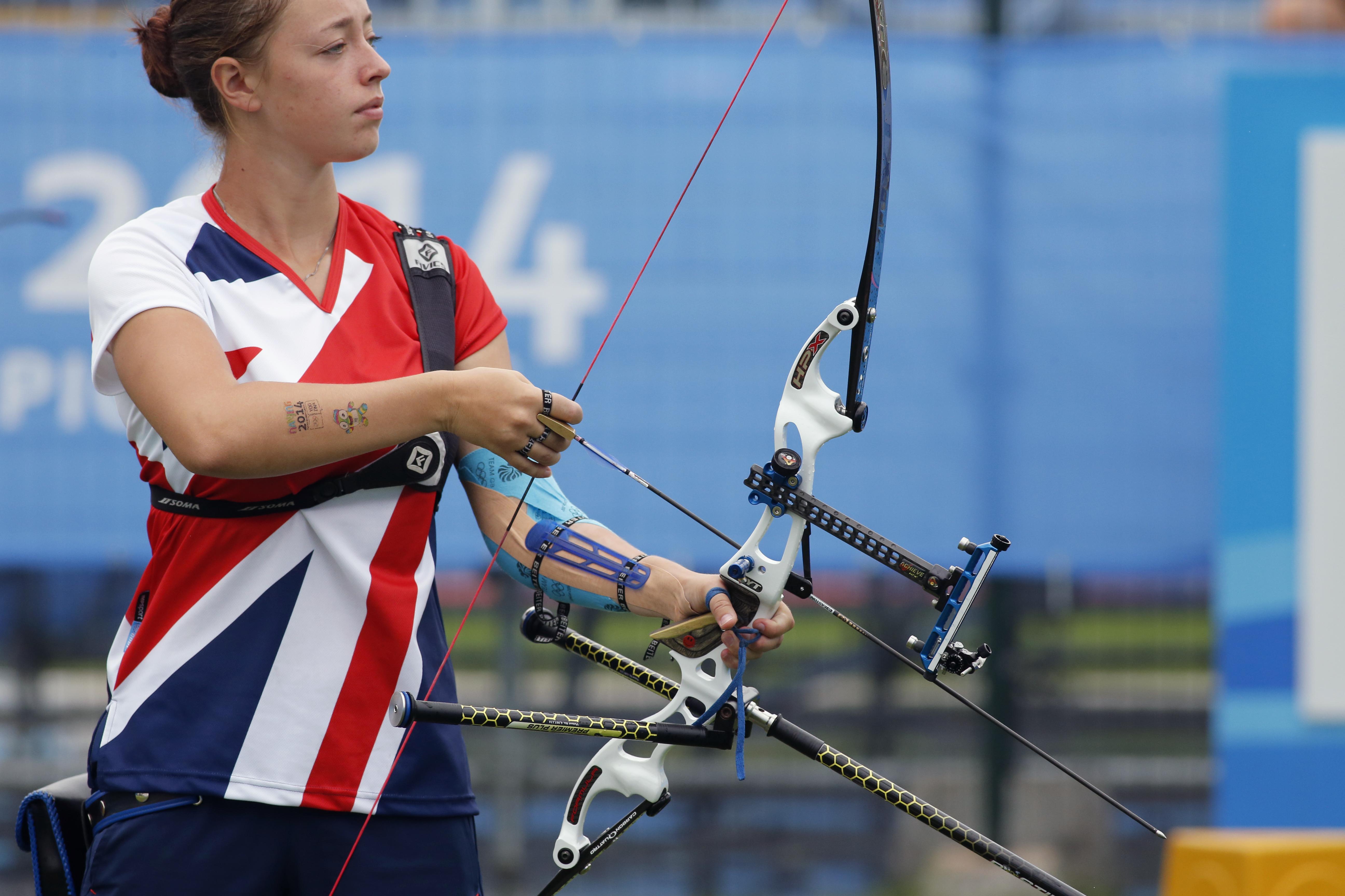 Archer with the bow in one hand and holding the arrow in the other hand, looking foward.