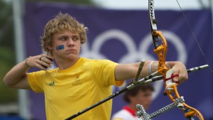Archer looking forward, having just released his arrow, holding on to the bow with his left arm.