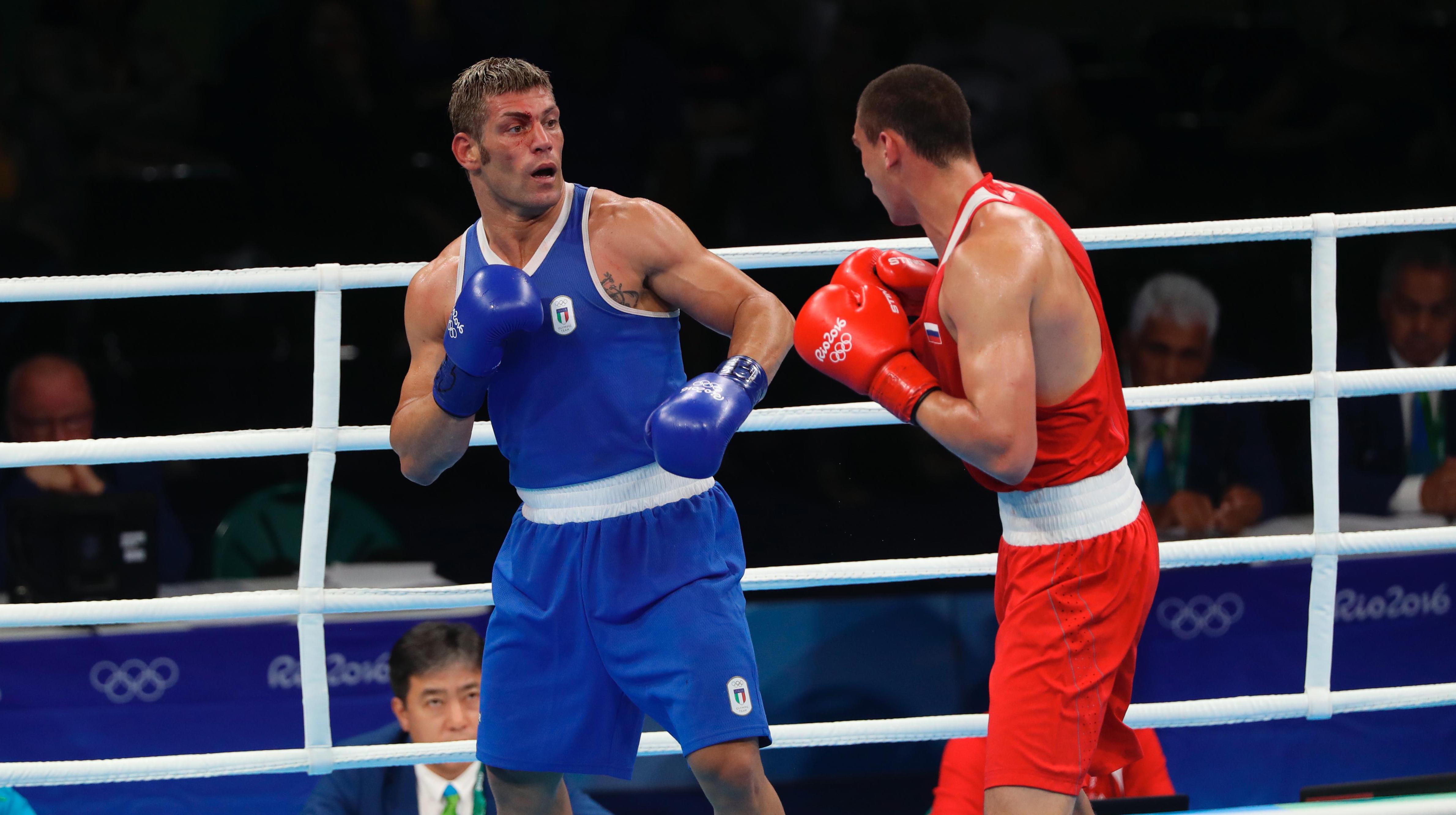 Two boxers in the ring, fighting each other, with gloves and no helmet.