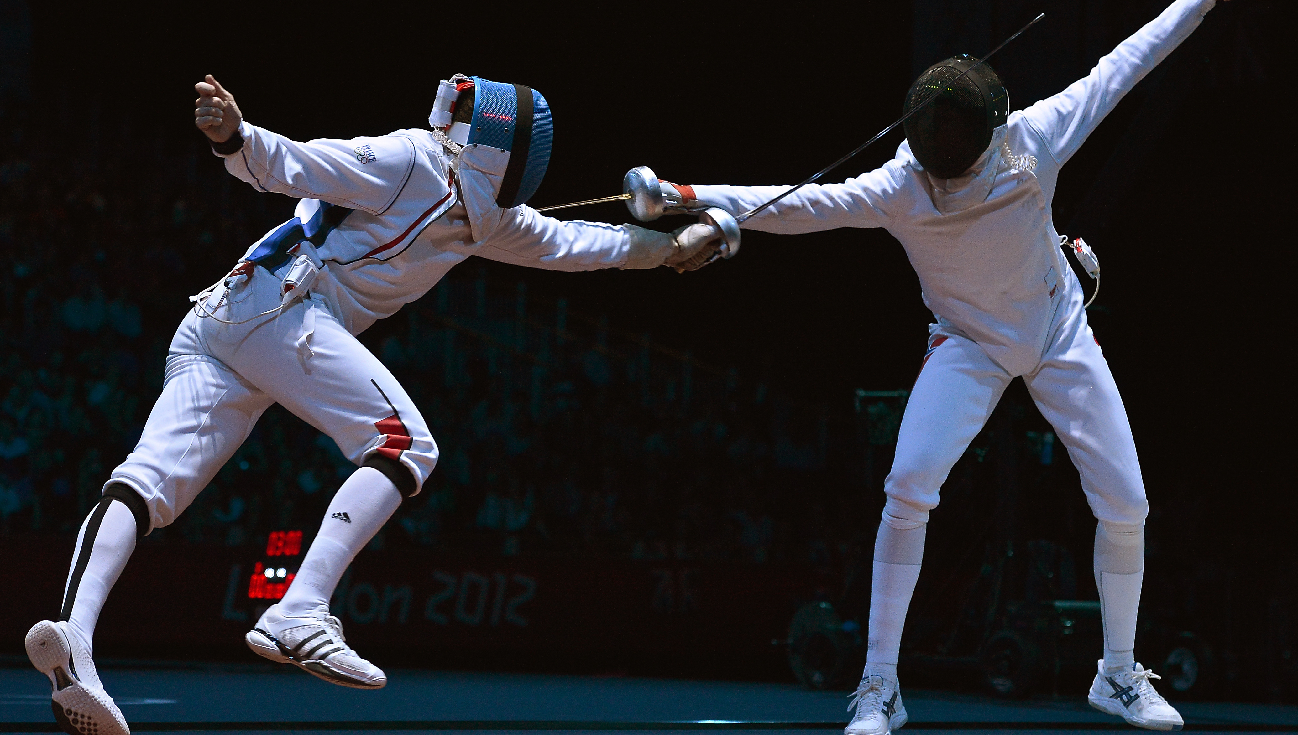Two fencers in a match, both trying to catch the other with the cord.