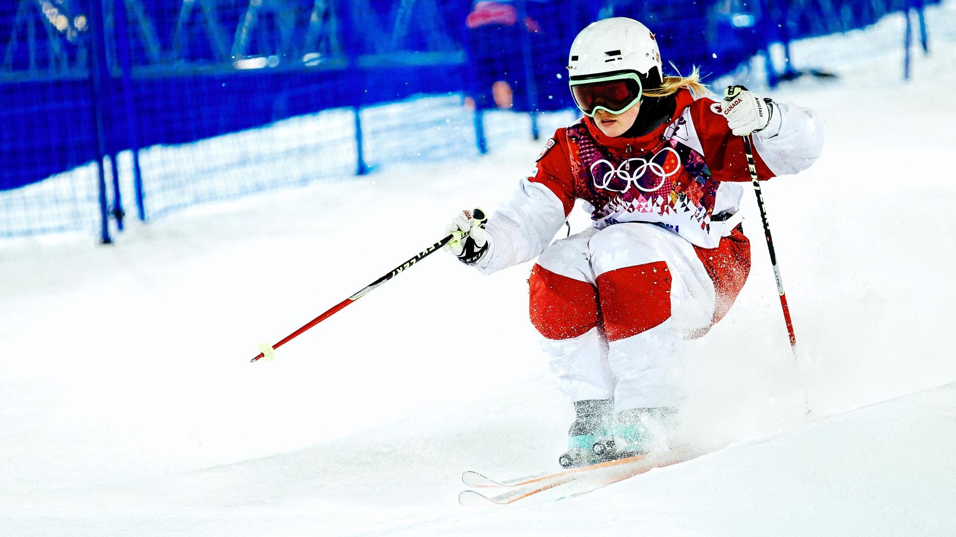 Mogul skier in the slope during a competition, legs together and eyes forward.
