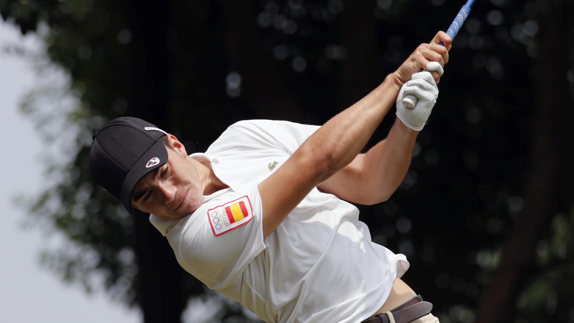 Golfer swining a stroke with the golf club, looking down, close up.