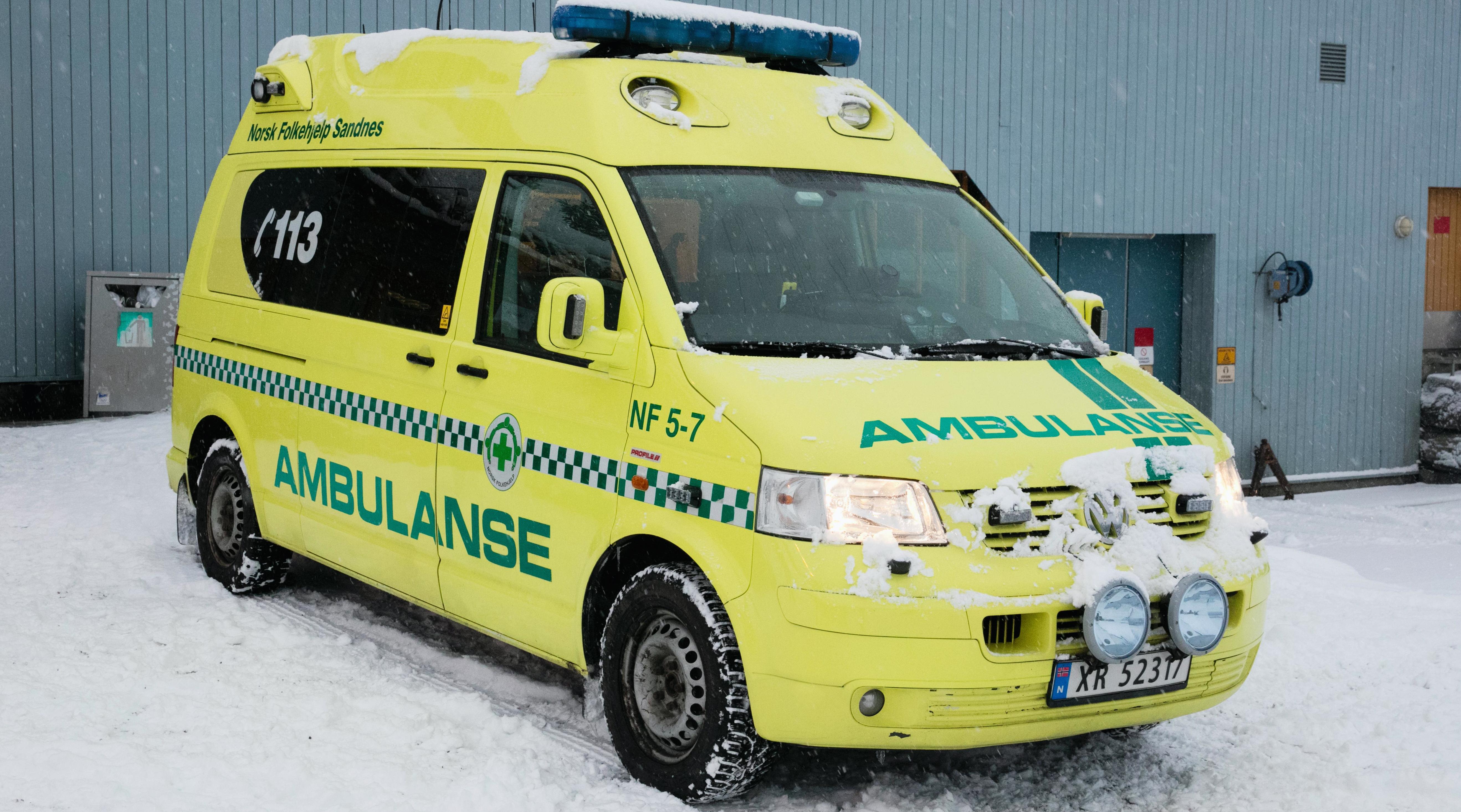 Yellow ambulance parked in the snow.