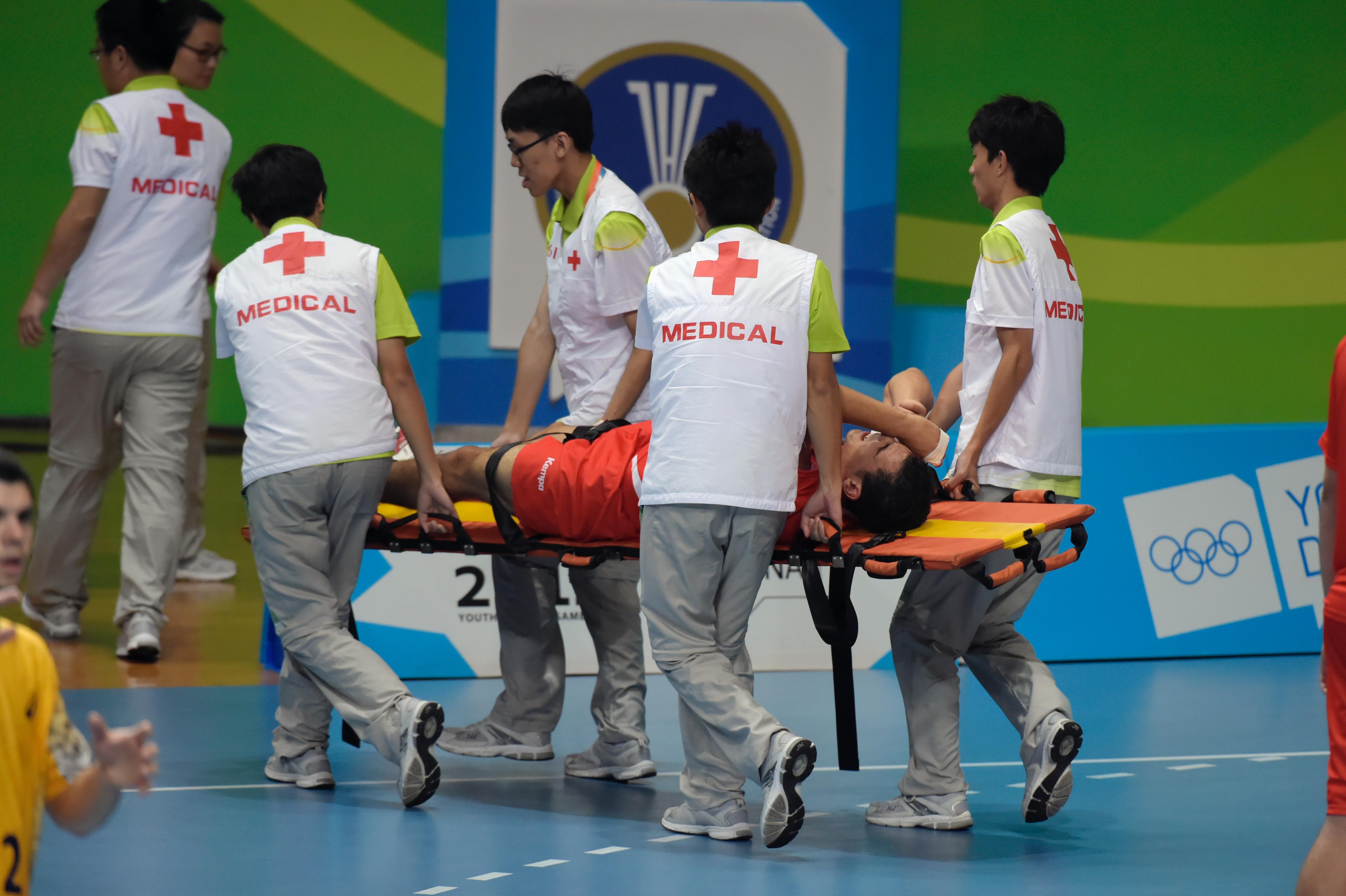 Severla medical personel carrying a player off the court on a stretcher.