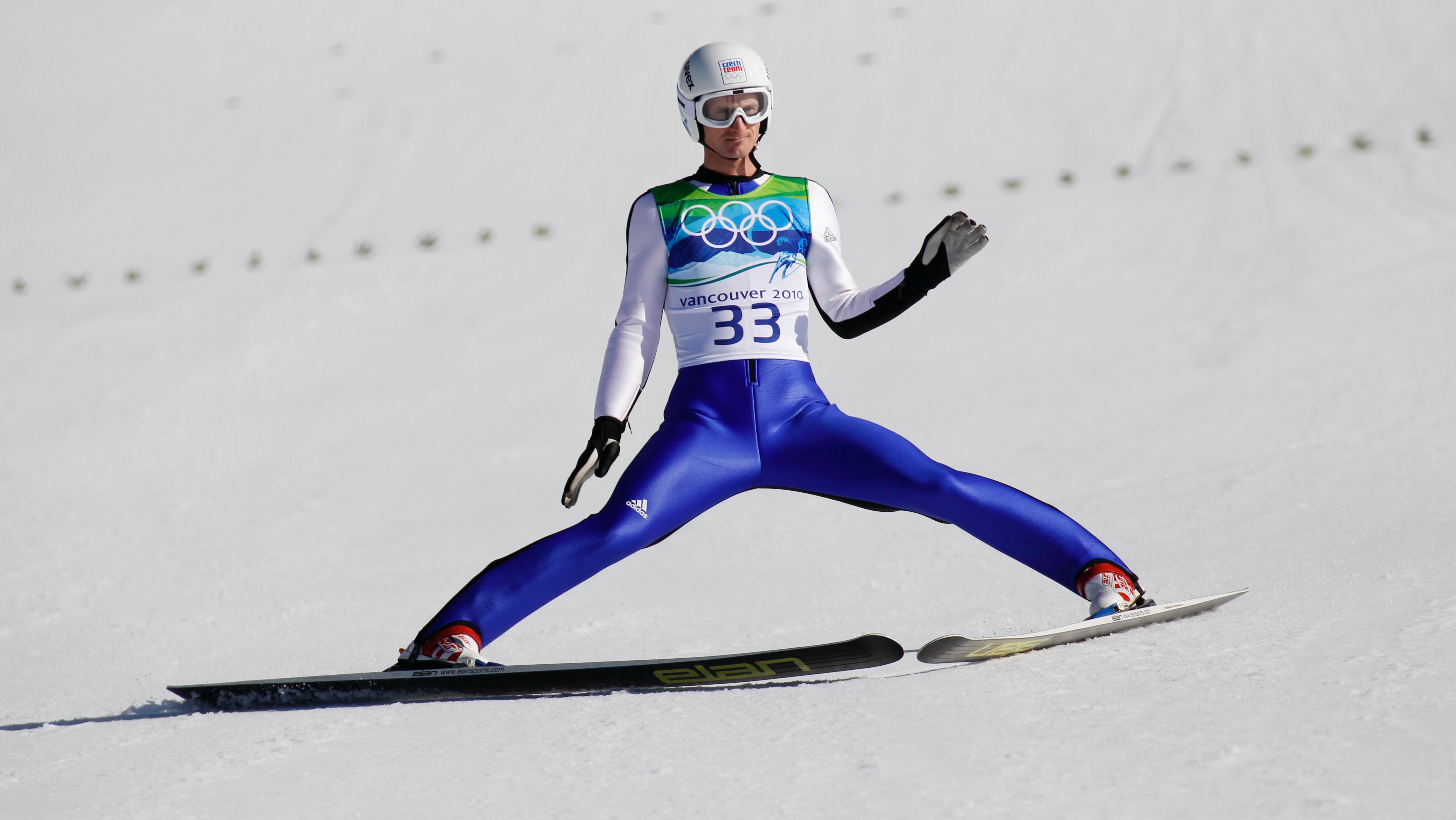 Ski jumper athlete after a jump on the flat snow, plowing to breake with his skis.