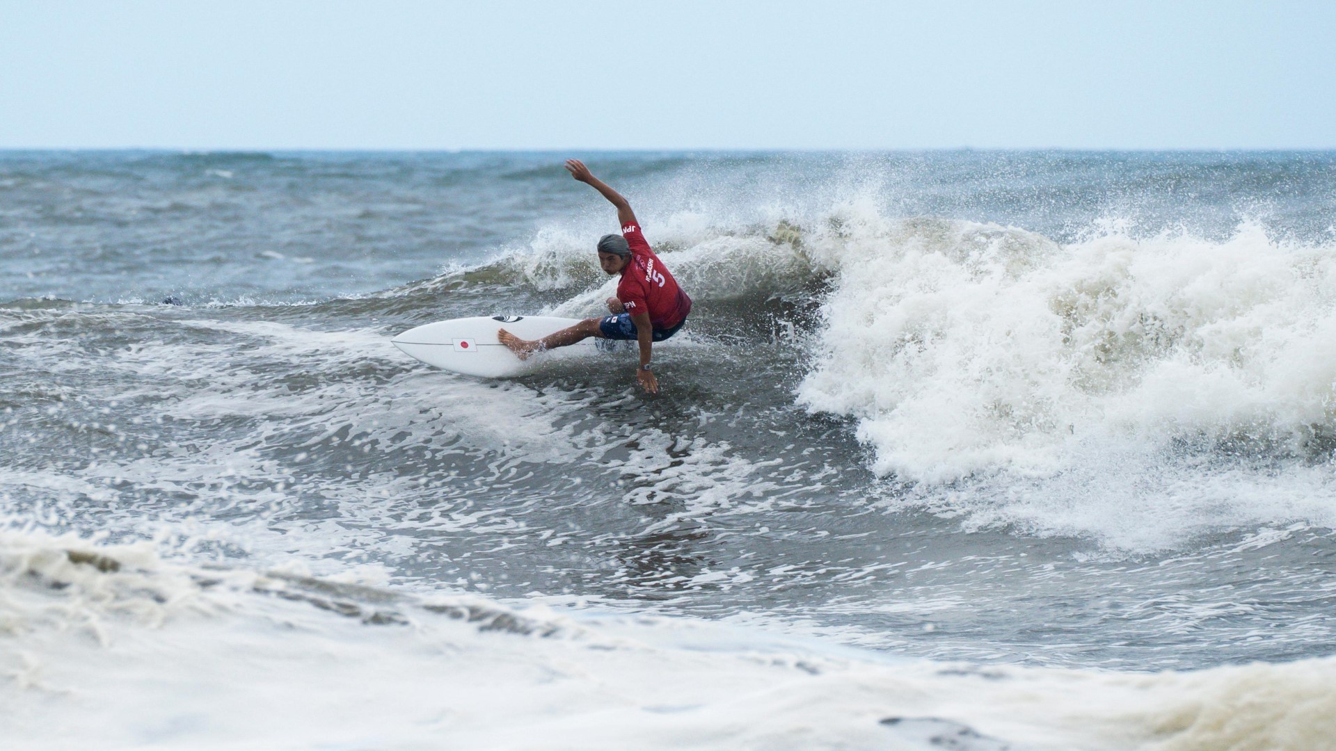 Athlete on a surfboard on a wave, turning on the wave.