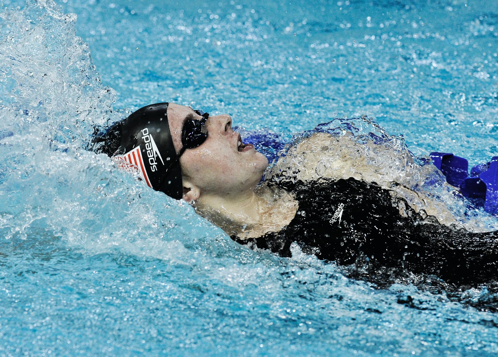 Swimmer in the pool, backwards swimming, lying a bit on the side.