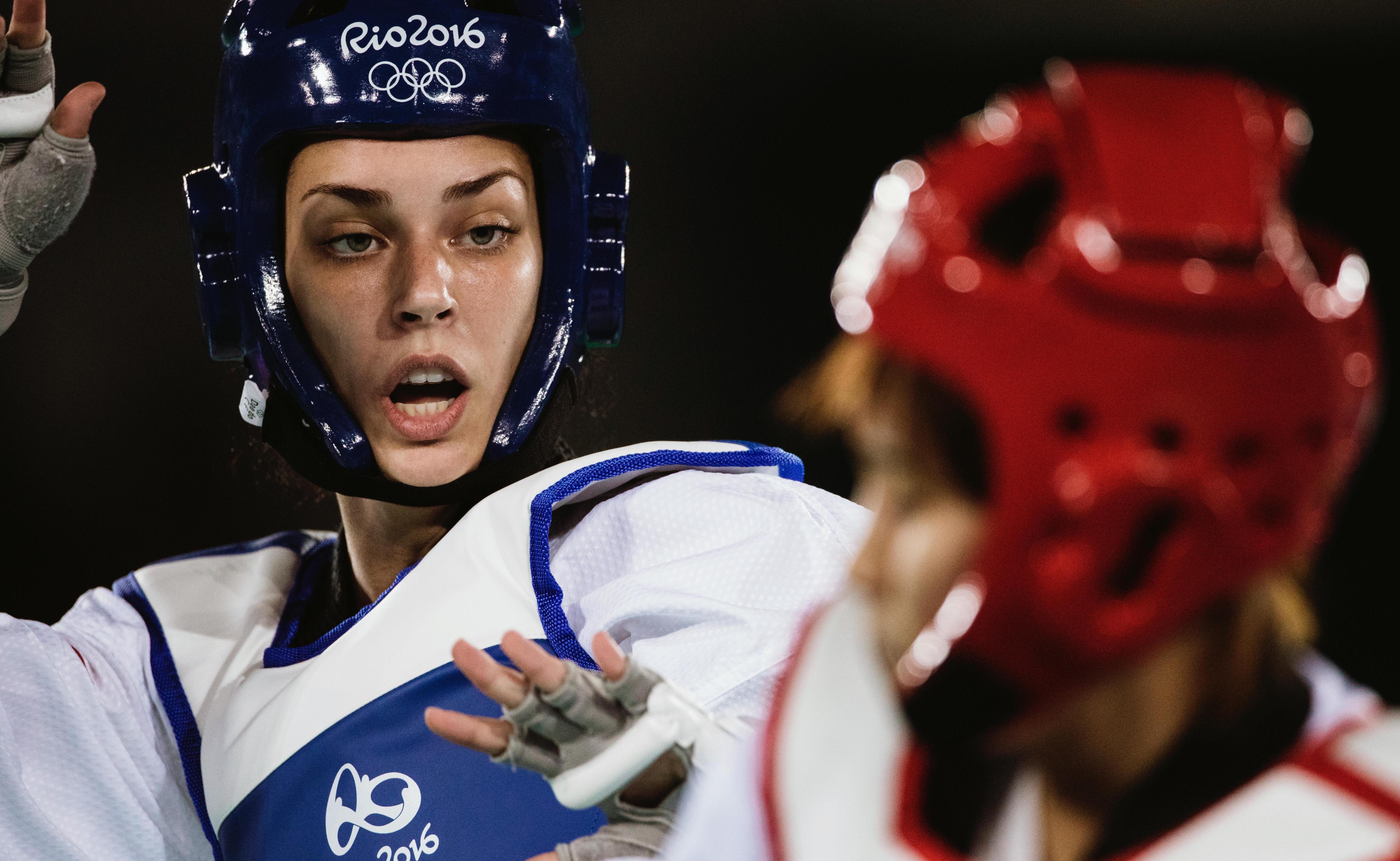 Two athletes in an Olympic competition, close up of one of the athletes face, looking towards her opponent.