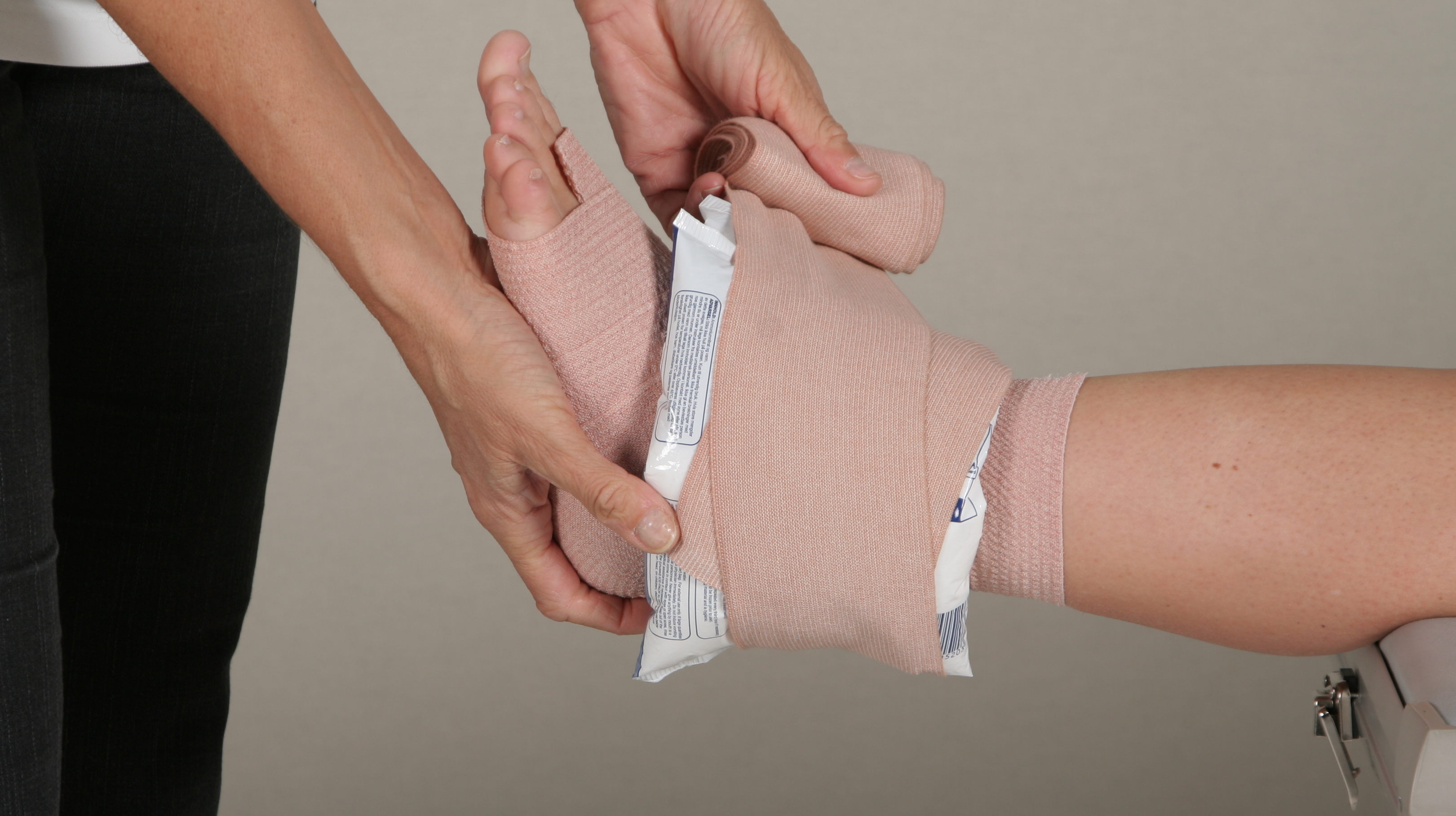 Close up of a patient who gets their ankel compression on by a physician.