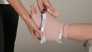 Close up of a patient who gets their ankel compression on by a physician.