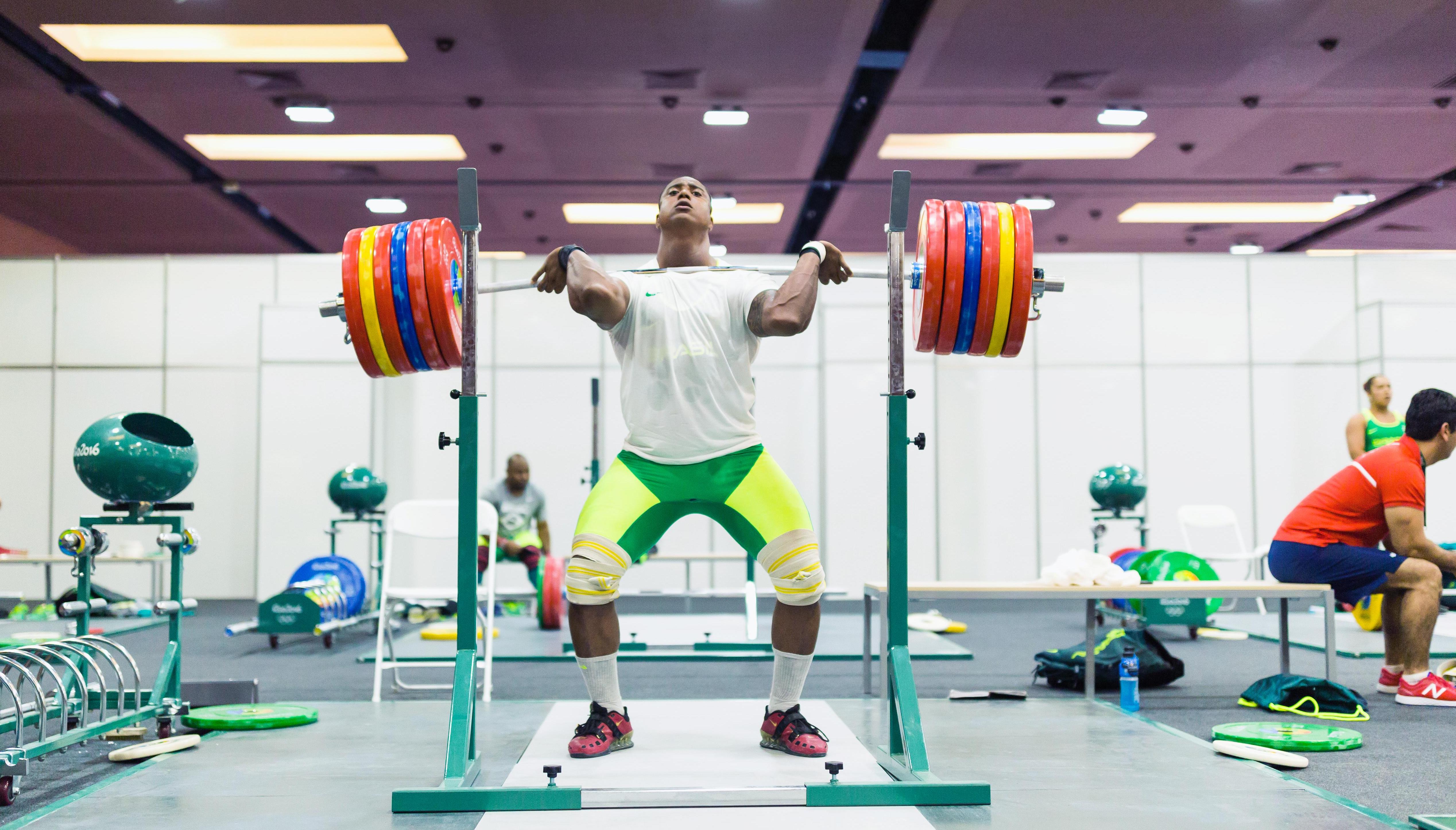 Athlete in the gym lifting weights, having the wights on his chest, getting ready to lift.