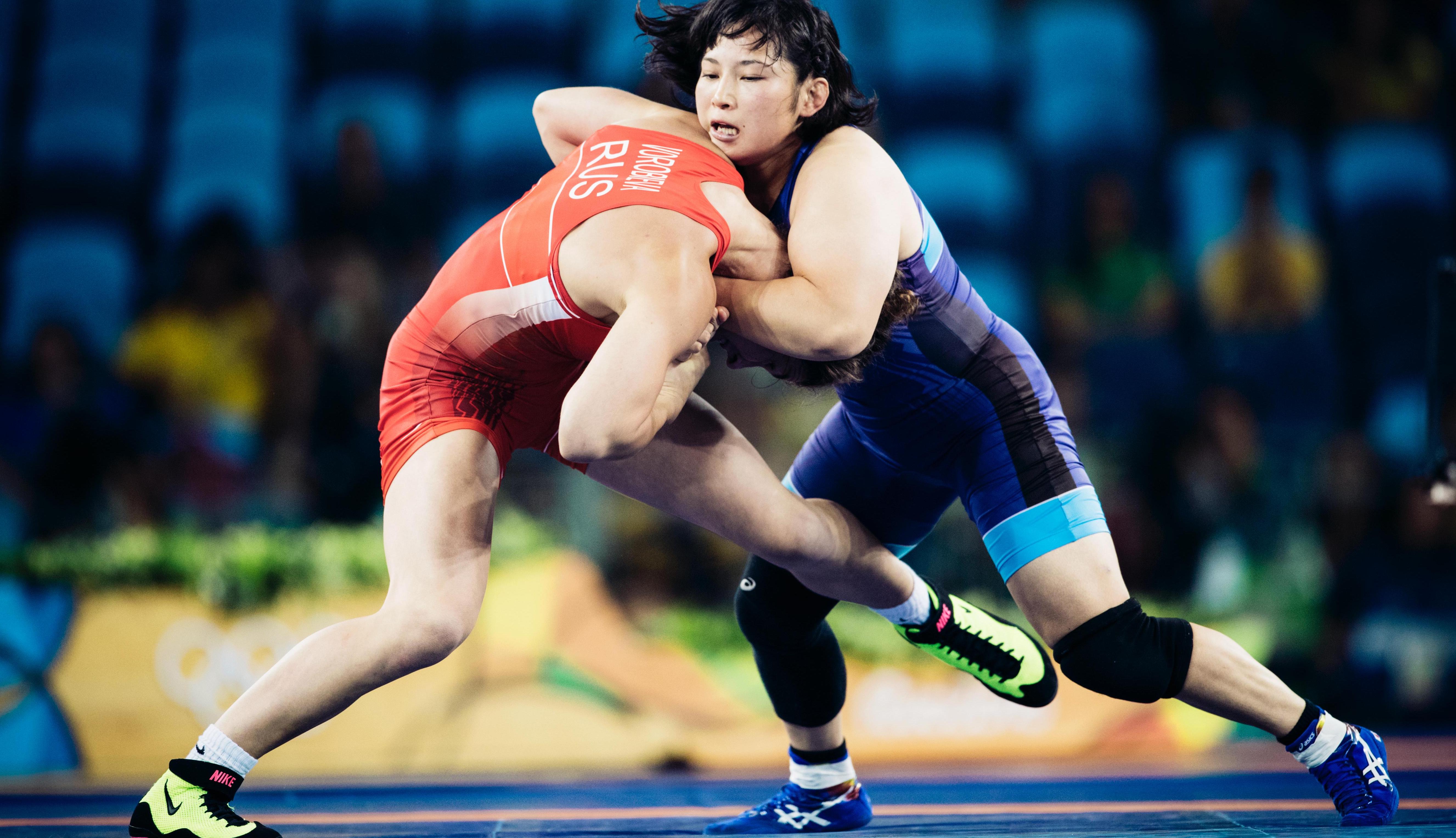 Two wrestlers in a match, one athlete has a head-grip on the other athlete.